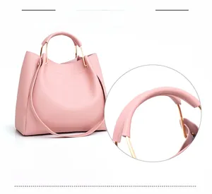 Close-up of pink tote bag showing the golden metal ring handle and textured leather finish