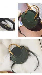 Detail of vintage green round crossbody bag with gold rivets and metallic handle