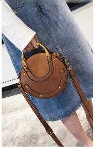 Detail of round crossbody bag featuring frosted texture splicing and U-shaped stitching
