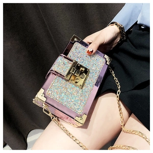 Detail view of purple transparent sequin mini box bag with gold metal corners and chain