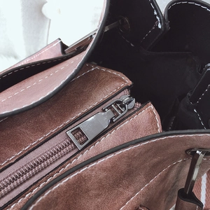 Retro brown suede bucket bag with wide strap and detailed white contrast stitching