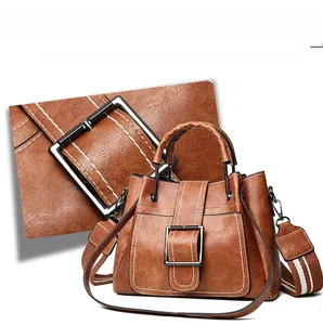 Detailed view of brown bucket bag with metal buckle and decorative white stitching
