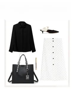 Chic ensemble with black croc-pattern handbag, polka dot skirt, and elegant accessories