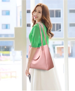 Detail showing pink faux leather tote bag texture and reinforced metal strap rings