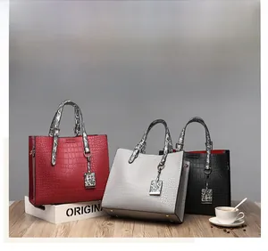 Three crocodile pattern handbags in red, grey, and black with snake print handles