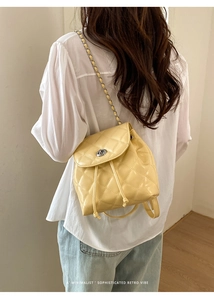 Detail of light yellow quilted PU leather backpack with chain strap and drawstring closure