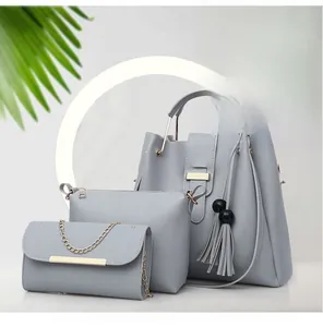 Three-piece light blue faux leather handbag set with tote, clutch, and chain bag