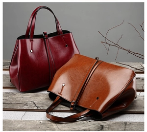 Détail de sacs cabas rouge et marron montrant le cuir ciré brillant et le style vintage
