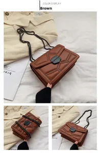 Detail of brown square crossbody bag with rivet geometric quilting and black hexagon clasp