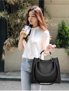 Close-up of black lychee grain tote bag with gold hardware and removable shoulder strap