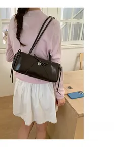 Elegant solid color shoulder bag with ribbon bow and heart pendant in polished finish