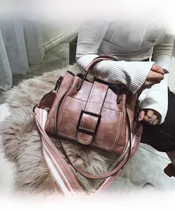 Detail of retro pink-brown bucket bag with wide fabric strap and metal buckle