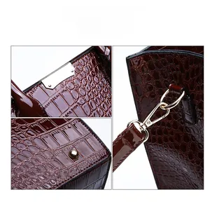 Detailed views of crocodile pattern leather tote with gold hardware and protective studs