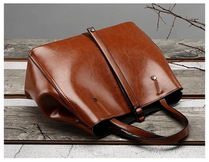 Vue détaillée de la texture en cuir ciré marron foncé et des coutures du sac cabas