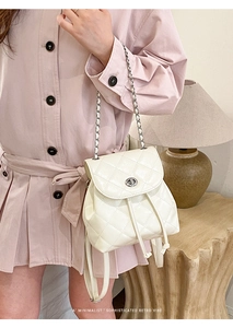 Quilted beige backpack with chain strap and retro design shown in lifestyle scene