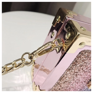Detail of pink mirror mini box bag with gold metal corners and glittery side texture