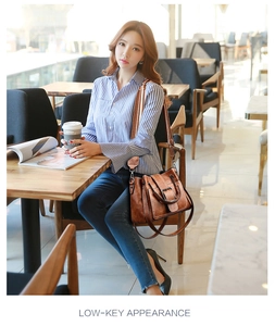 Brown vintage PU leather bucket bag with white contrast stitching and wide metal buckle detail