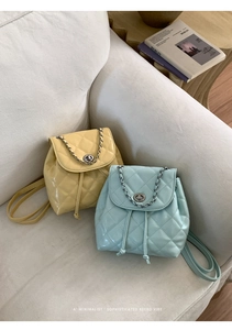 Detail of quilted mini backpacks in yellow and blue with gold chain handle and metal lock