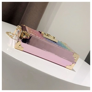 Detail of pink glitter evening clutch with golden metal corners and chain strap