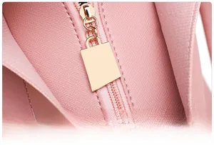 Detailed macro view of the rose gold smooth zipper on pink cross-grain leather bag