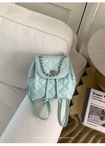Detail of mint green quilted patent leather backpack with silver chain and twist lock