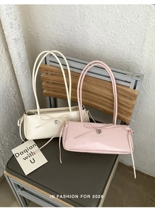 Detail of elegant shoulder bags with bow accents and heart charms on a vintage chair