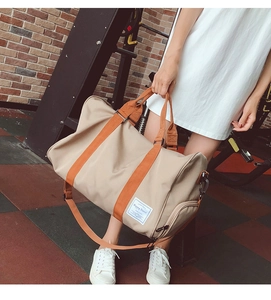 Détail du sac de voyage kaki avec sangles orange et compartiment à chaussures séparé
