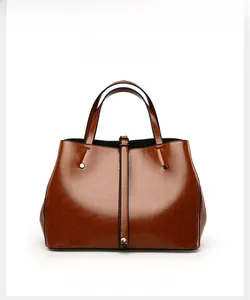 Détail du sac cabas marron vintage avec finition cirée brillante et rivets sur lanières
