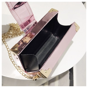 Detail view of pink metallic box bag with gold corner guards and chain strap