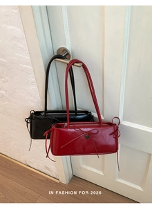 Detailed view of red and black chic underarm bags with bow and heart pendants hanging
