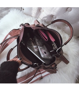 Close-up of the spacious interior of a pink leather bucket bag with a striped wide strap