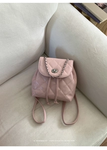 Detailed view of pink quilted leather backpack with chain detail and metallic twist lock