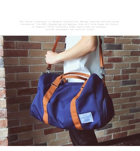 Détail du sac de voyage bleu marine avec sangles marron et poche latérale zippée