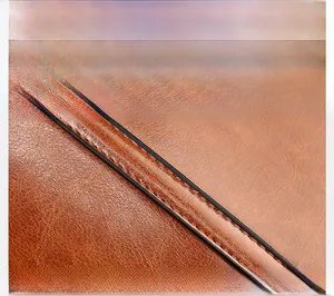Macro shot showing high-quality stitching detail on the brown PU leather shoulder bag