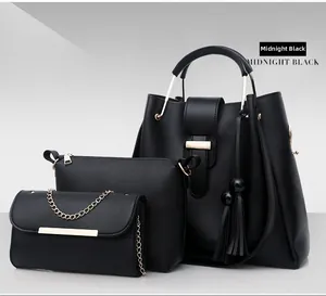 Detailed set of three midnight black tote, crossbody, and clutch bags with gold hardware