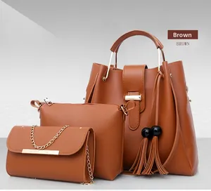 Detailed view of 3-piece brown PU leather handbag set with tassels and gold hardware