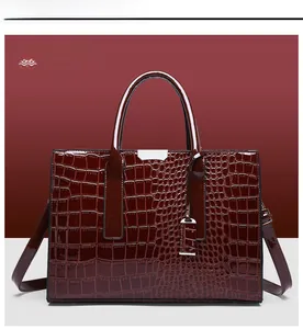 Detailed close-up of a wine red tote bag with glossy crocodile embossed leather texture