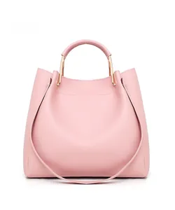 Side view of pink leather tote bag featuring gold U-shaped metal handle hardware