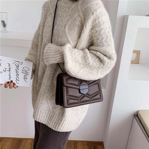 Vintage dark brown crossbody bag with geometric quilting and studs on beige sweater