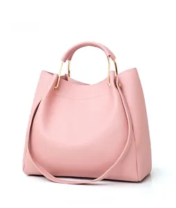 Pink faux leather tote bag featuring elegant golden semi-circular metal handles and a slim strap