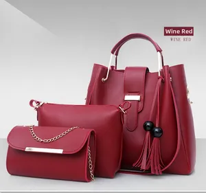 Detailed view of the 3-piece wine red tote bag set with golden hardware and tassel