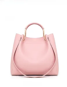 Close-up of pink tote bag with cross-pattern leather and gold metal handles