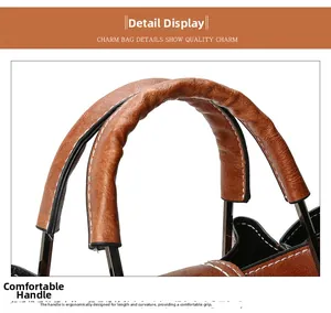 Detail of the brown bucket bag handle with white contrast stitching and black metal hardware