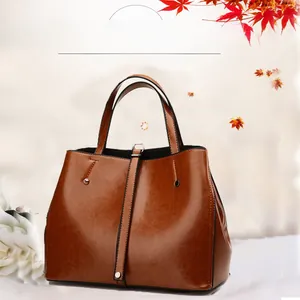 Détail du grand sac cabas en similicuir marron avec boucle décorative et rivets en métal
