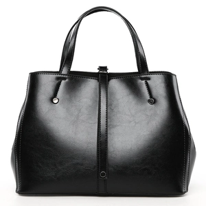 Détail d'un sac cabas noir en cuir avec texture naturelle et rivet métallique argenté élégant