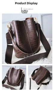 Detail view of coffee brown crocodile pattern bucket bag with wide woven strap