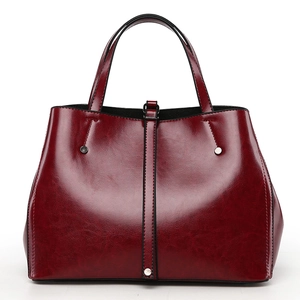Détail du sac cabas en similicuir rouge foncé avec texture brillante et rivets argentés