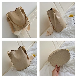 Detail shots of beige crocodile pattern bucket bag with wide strap and gold hardware