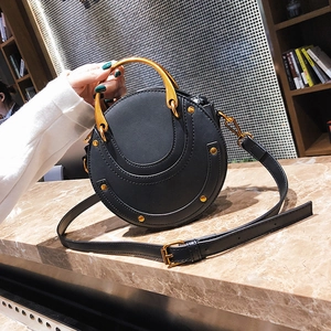 Borsa a tracolla rotonda nera con doppi manici in metallo dorato e borchie decorative