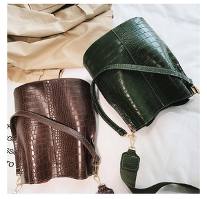 Close-up of crocodile pattern leather texture on stylish bucket bags in green and brown